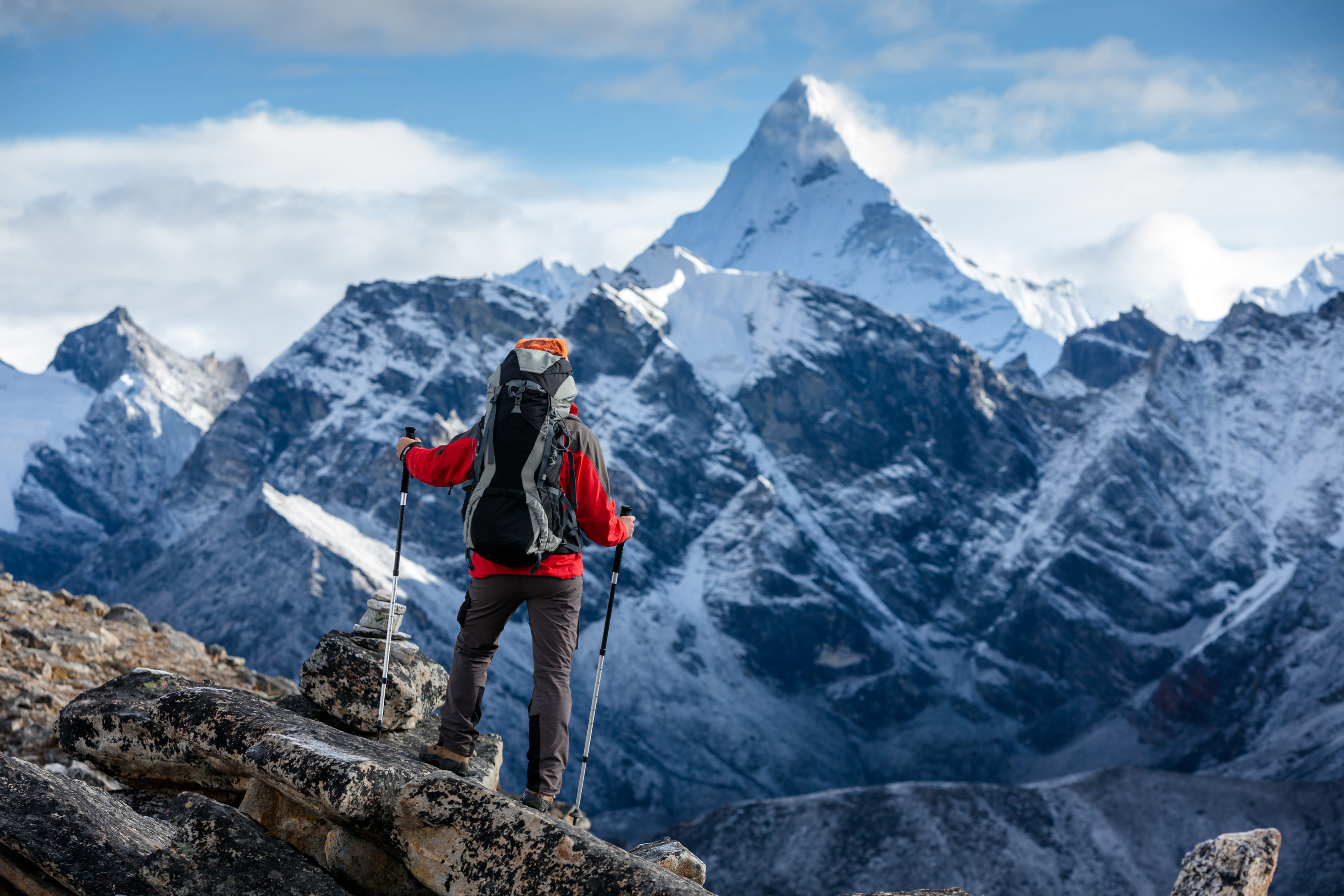 Wanderer steht vor einem Berg. Reisearten, wie aktiv sein, werden hier dargestellt